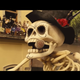 A huge skull parade float is shown wearing a hat and smoking a cigar.